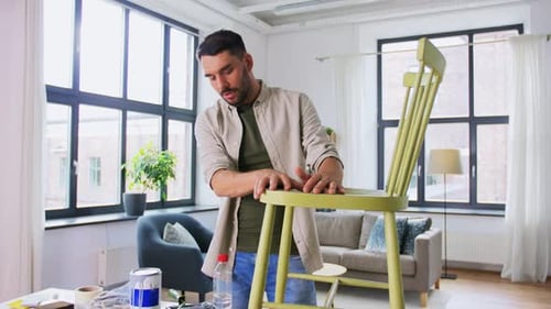 Man Showing Painted Chair in Bright Room