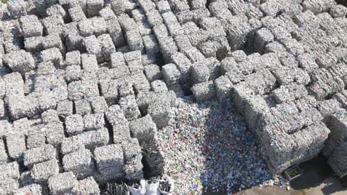 Aerial view overlooking large garbage cubes, sunny day at a junkyard