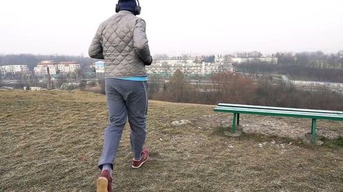 Male Jogger in Headphones Running in City Park, Super 240