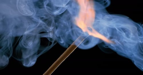Burning matchstick close-up on a dark background. Shot on super slow motion camera 1000 fps.