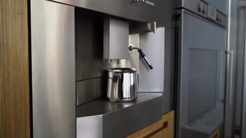 Modern Coffee Maker Brewing into Silver Pitcher
