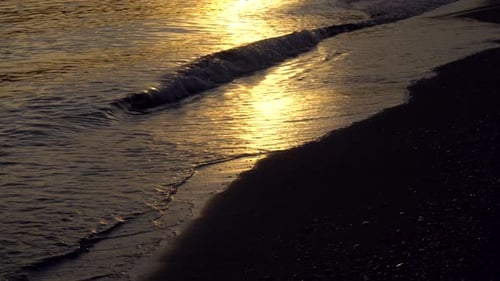 Ruhige Meereswellen am Strand bei Sonnenuntergang