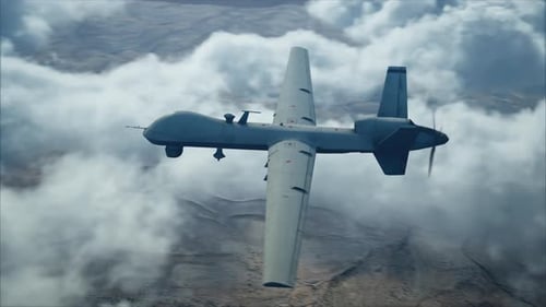 Military Drone Flying Over Desert Mountains Through Clouds