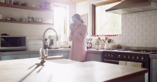 Young Adult Woman Drinking Coffee in Bright Kitchen