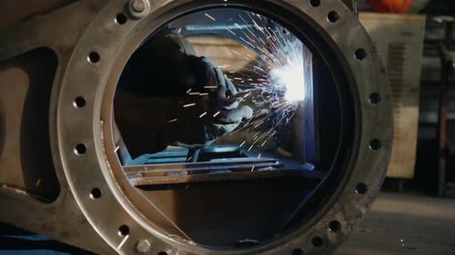 Hands of Factory Worker Welding Metal Construction with Gas Torch