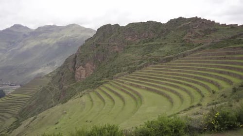 Ancient Inca platforms with mountains in the background in Pisac Archaeological Park in Pisac,