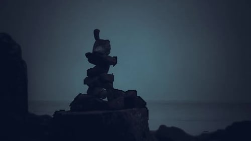 Stacked Stones Create a Silhouette Against the Evening Seascape