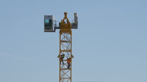 Mann arbeitet ohne Sicherheitsausrüstung an einem Derrick