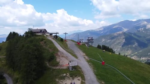 An aerial shot of a ski lift in the French Alphs during the summer.