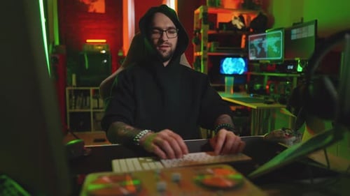 Hacker Writing Code Cracking Computer Man Programmer in Hoodie Cracks System Using Computer in Dark