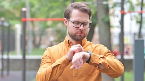 Man Using Smartwatch Outdoors in Urban Setting