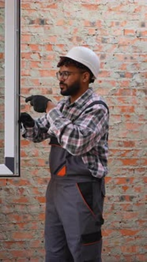 Construction Worker Installing Window with Screwdriver