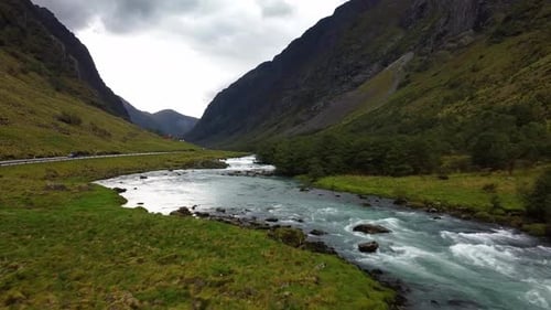 Breathtaking Drone View of Glacial River Winding Through Deep Valley
