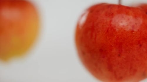 Extreme Close Up Ripe Tasty Apple Spinning in Slow Motion with Blurred Fruit Rotating at White