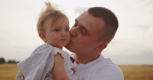 Father Kisses Baby in Rural Setting