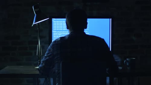 Man Typing Code at Computer at Night