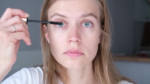 Woman Applying Mascara in a Close Up Shot