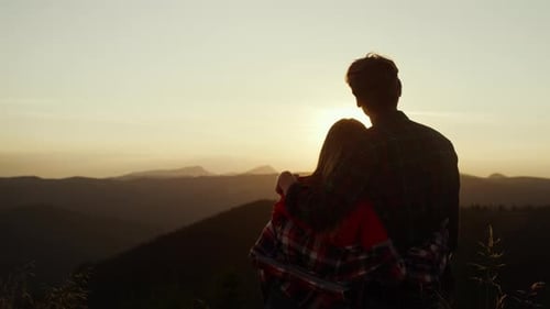 Romantic Couple Embracing on Mountain Top at Sunset