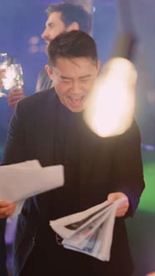 Chefe asiático feliz lendo relatório em papel sobre festa corporativa comemorando o sucesso da empresa com