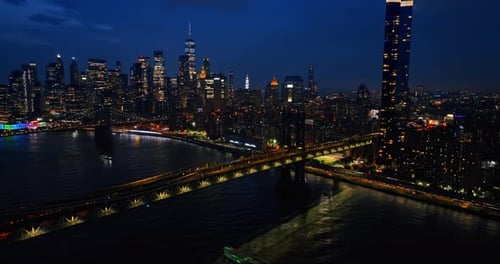 Sparkling skyline of New York at night. Drone footage of the urban scenery from above the river.