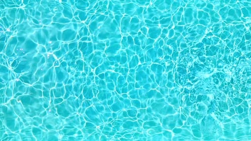 Ralentissement de l'eau bleue dans la piscine avec des reflets lumineux