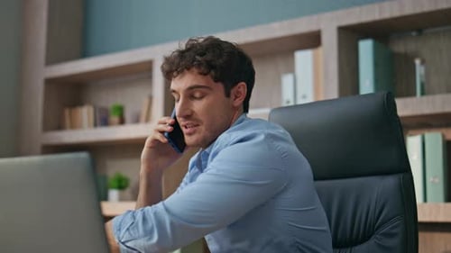 Young Adult Talking on Phone at Desk