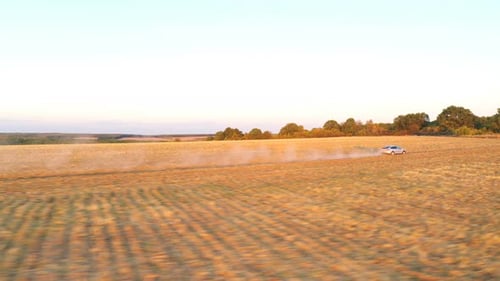 Aerial View of Electrical Car Speeding Through Offroad Route with Dust Trail Behind