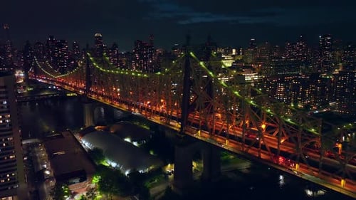 Beautifully highlighted Queensboro bridge at nighttime. Drone flying over the vibrant city.