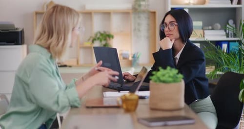 Two Female Teammates Working on Project in Office