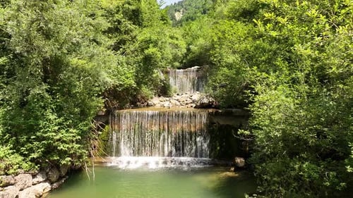 Drone Footage of a Beautiful Waterfall Cascading Through a Lush Green Forest