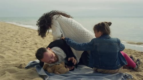 Playful Parents Child Enjoy Vacation On Sea Beach Picnic Outdoors. Happy Family Have Fun Together...
