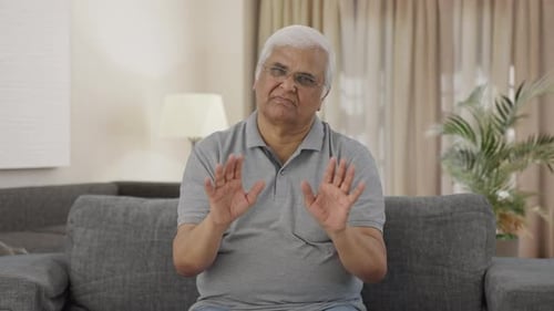 Senior Man Talking and Gesturing on Couch