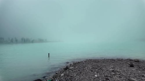 foggy, misty day at the beach with a small island in the distance.