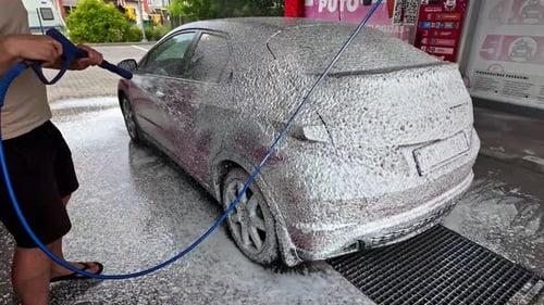 Man Washing Car with High Pressure Spray
