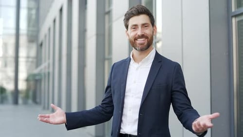 Man Smiling and Presenting Modern Building