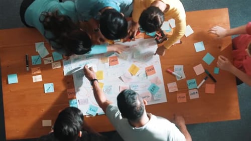 Top view of skilled project manager writing and sticking stick notes. Symposium.