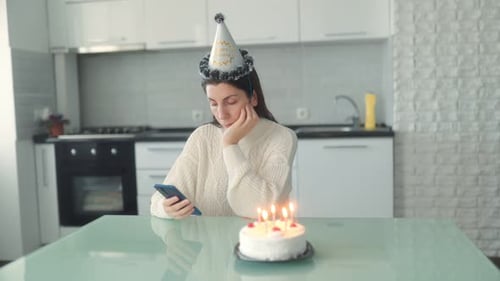 Lonely Woman with Birthday Cake Using Phone