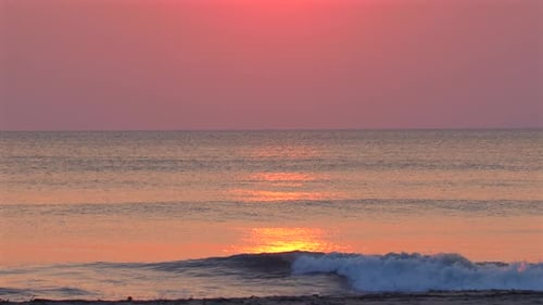 Serene Ocean Sunset with Gentle Waves on Shore Reflecting Orange Hues