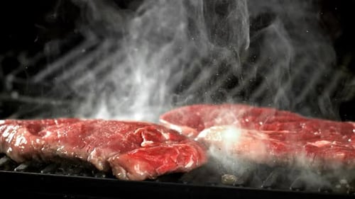 Raw Steaks on Grill Smoking