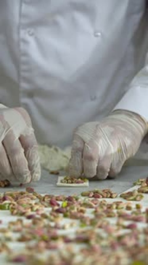 pastry chef adds pistachios to the sweets before grilling