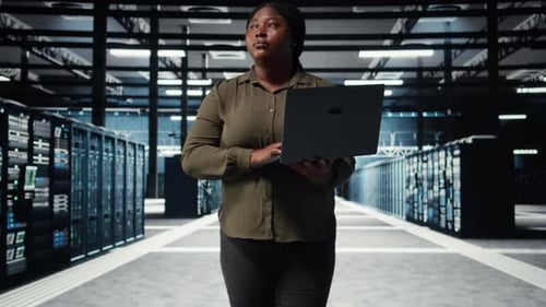 Supervisor em data center usando laptop para implantar nova arquitetura de servidor