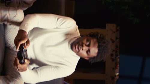 Man Plays Video Game on Sofa Indoors