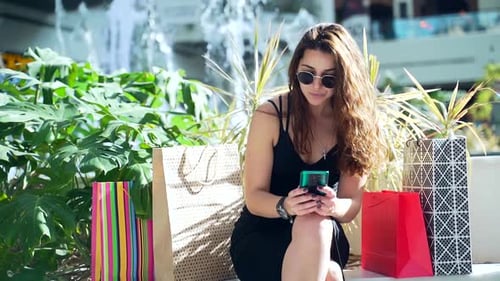 Fashionable Woman Using Phone at Shopping Mall