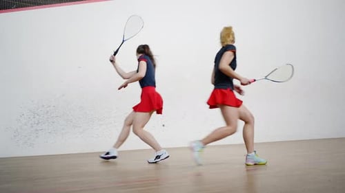 Female Athletes Compete in Skill By Playing Squash