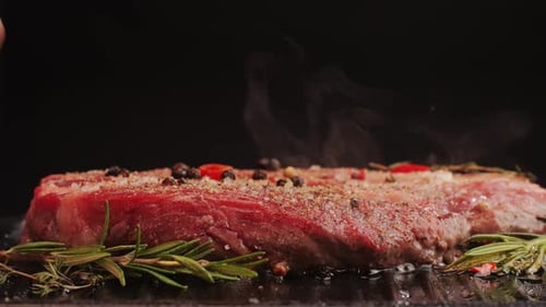 Fresh Marbled Beef with Pepper Salt and Rosemary Closeup Macro Cooking Juicy Steak on Grill with Oil