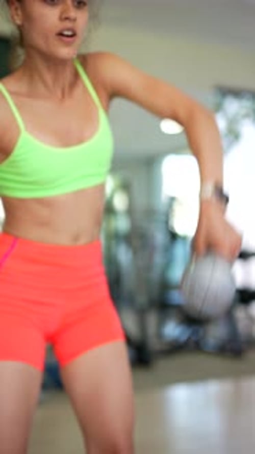 A Young Woman Works Out with Dumbbells at the Gym Showing Commitment to Health and Fitness