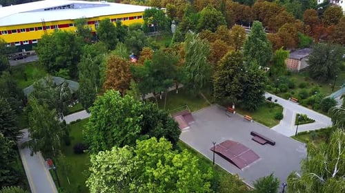 Der Wind weht heftig und erschüttert die Bäume im Stadtpark. Großer Springbrunnen im Stadtgarten. Luftbild.