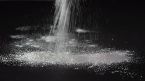Pouring White Powder on Black Background