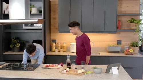Two Friends Cooking and Laughing in Modern Kitchen