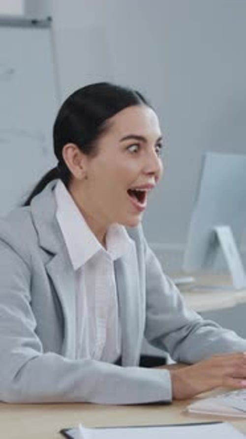 A Professional Woman Working Diligently at Her Desk in a Modern Office Environment